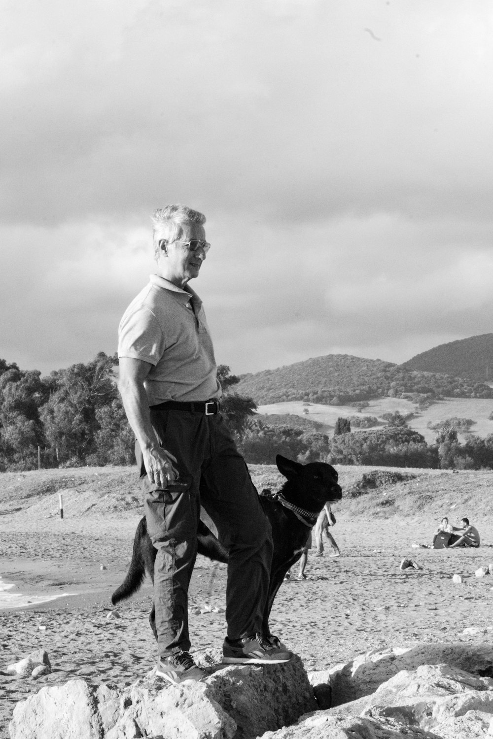 a man standing on a rock with a dog