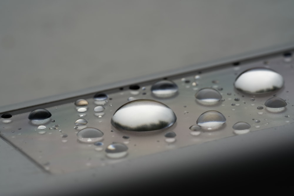 a close up of water droplets on a metal surface