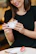 Happy woman holding a cup of freshly made makhana kheer in a bright dining room.