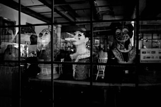 a black and white photo of mannequins in a store window
