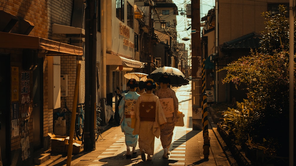 a couple of women walking down a street holding umbrellas