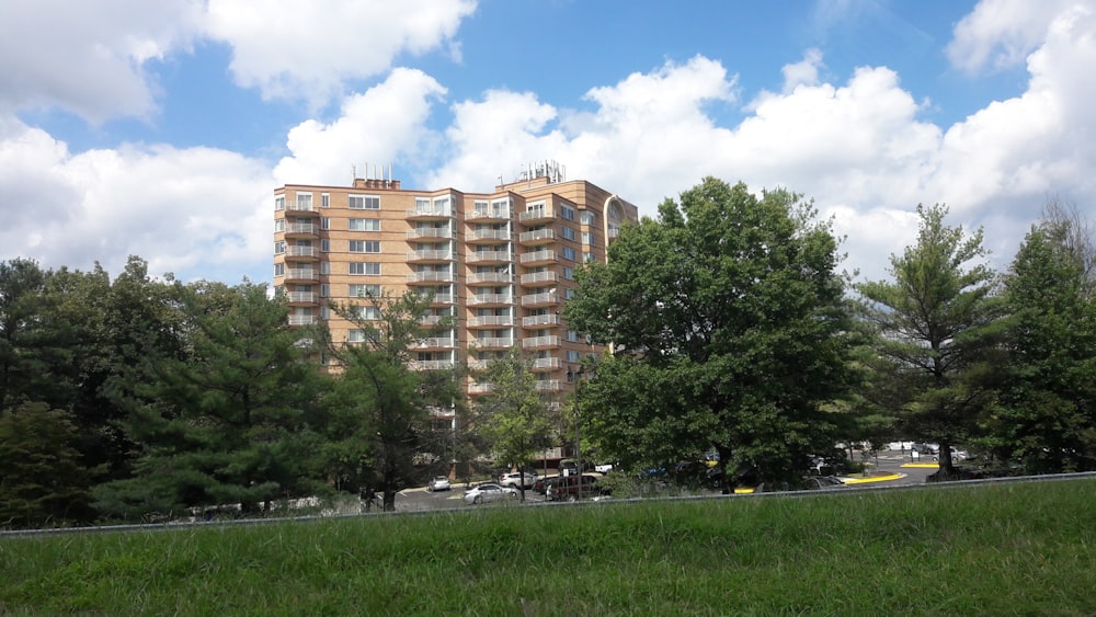 a tall building sitting next to a lush green forest