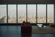 An elegant living room with large windows offering scenic views of the city skyline.