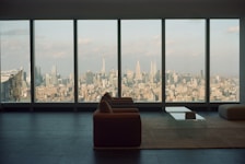 Cozy lounge space with comfortable sofa and cityscape visible from the window.