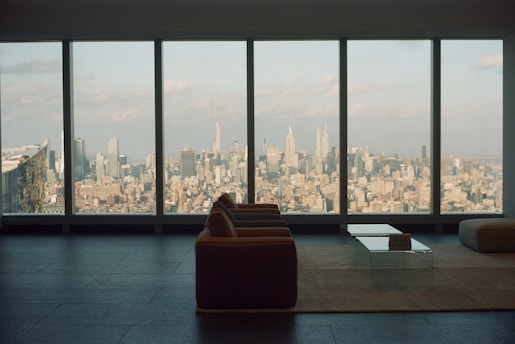 A modern living room with sleek furniture and large windows showcasing a beautiful view.
