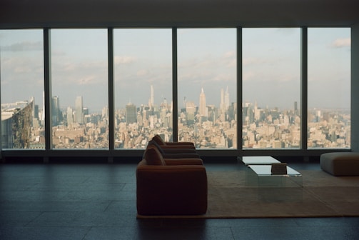 Spacious living area with stylish decor and a large window view.