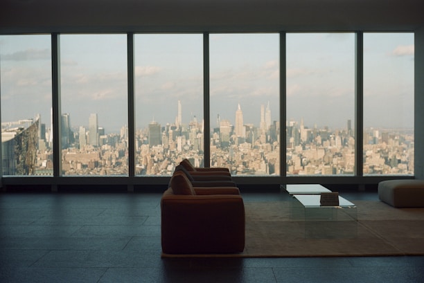 A cozy living room inside a well-lit apartment with stylish furniture and city views.