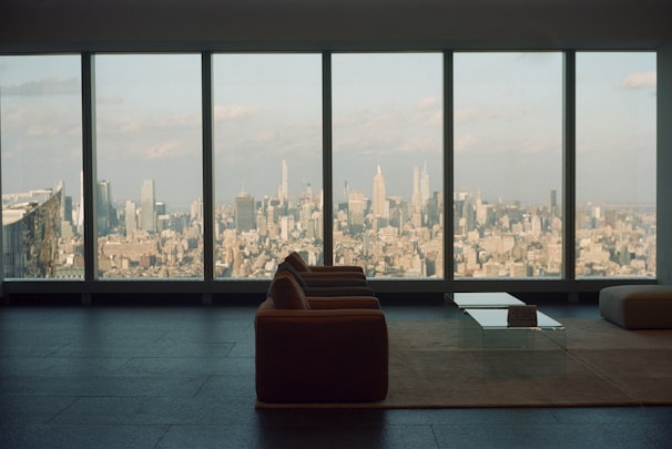 A bright, modern living room with large windows showcasing a city skyline view.