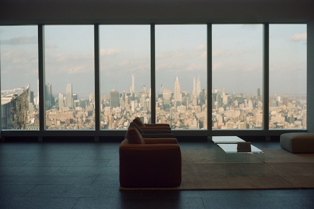 Bright, modern living room with large windows showcasing a city skyline view.