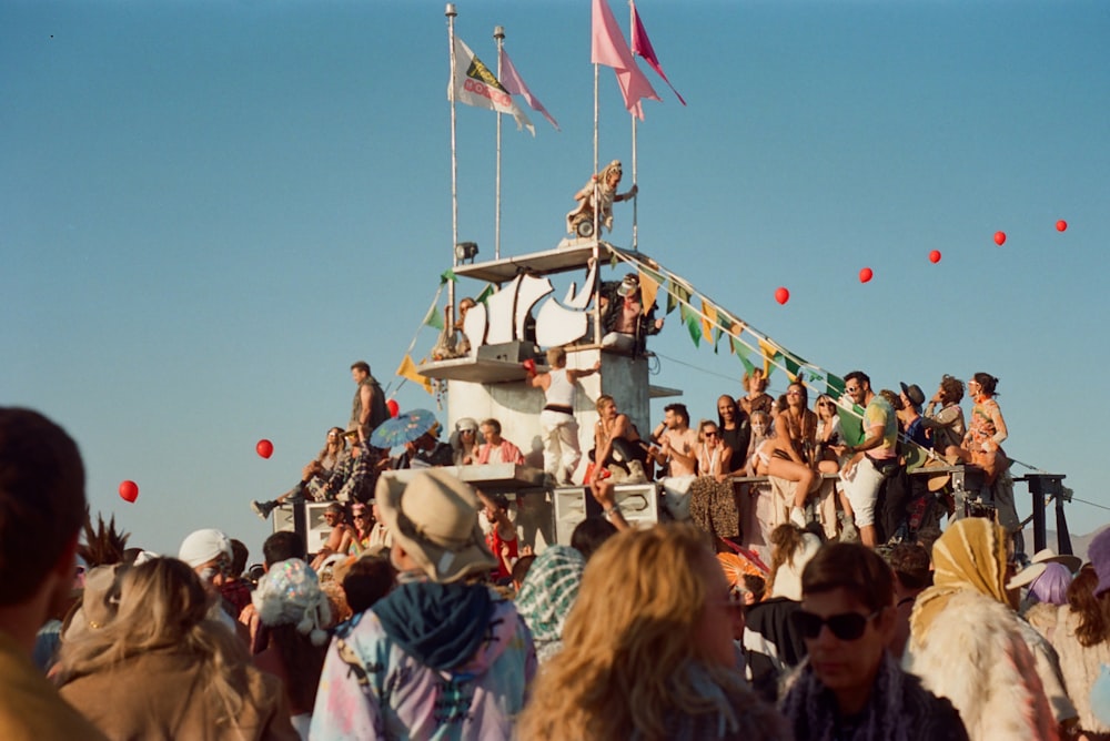 a crowd of people standing on top of a boat