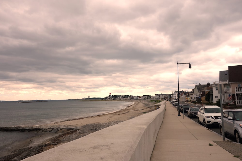 cars parked on the side of a road next to the ocean