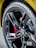 A close-up view of a car tire with a glossy black alloy wheel. The tire has the word 'Eagle' printed on it, and the wheel features a prominent black five-spoke design with a logo in the center. Behind the wheel, a red brake caliper is partially visible.