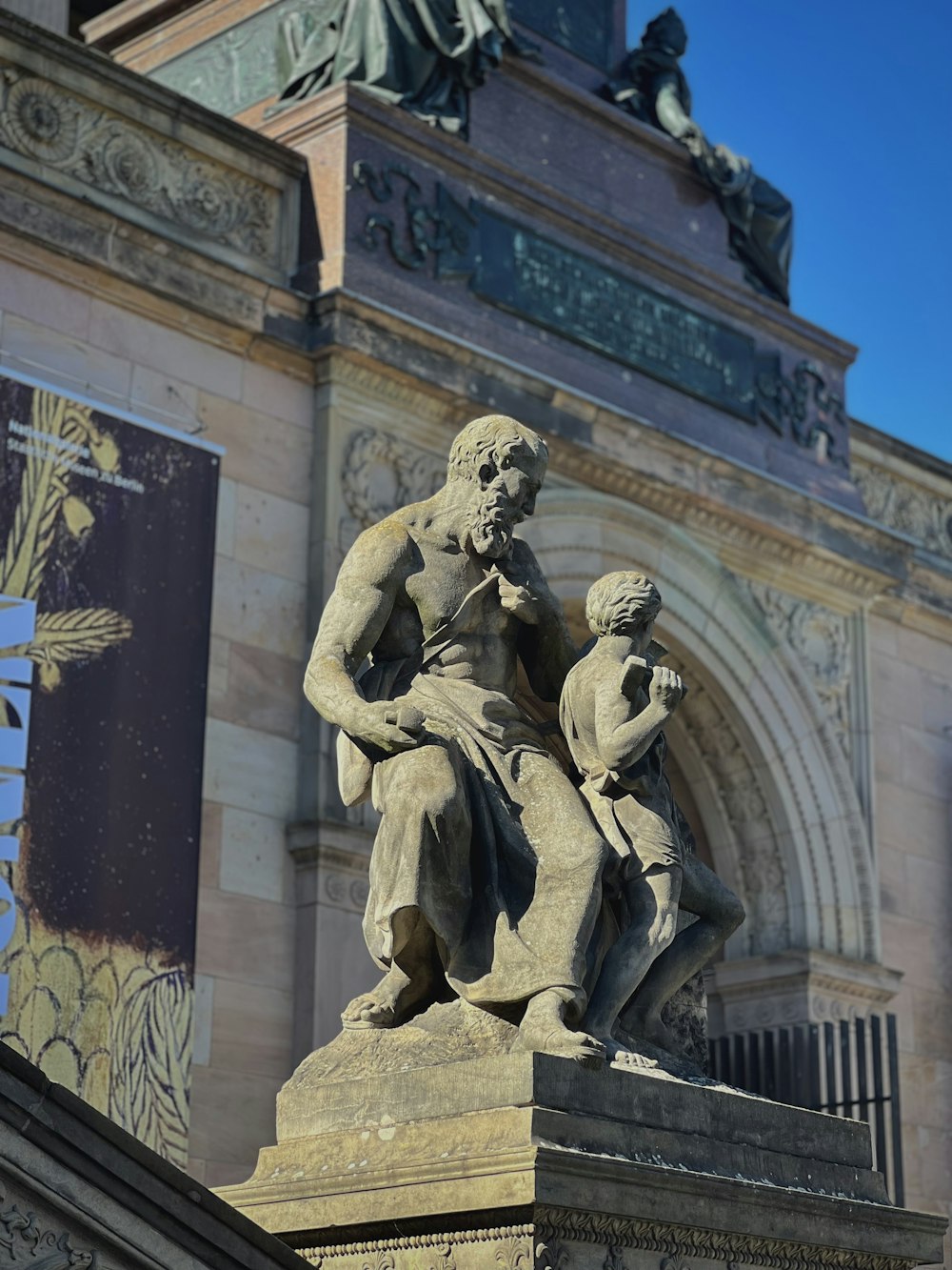 a statue of a man holding a child in front of a building