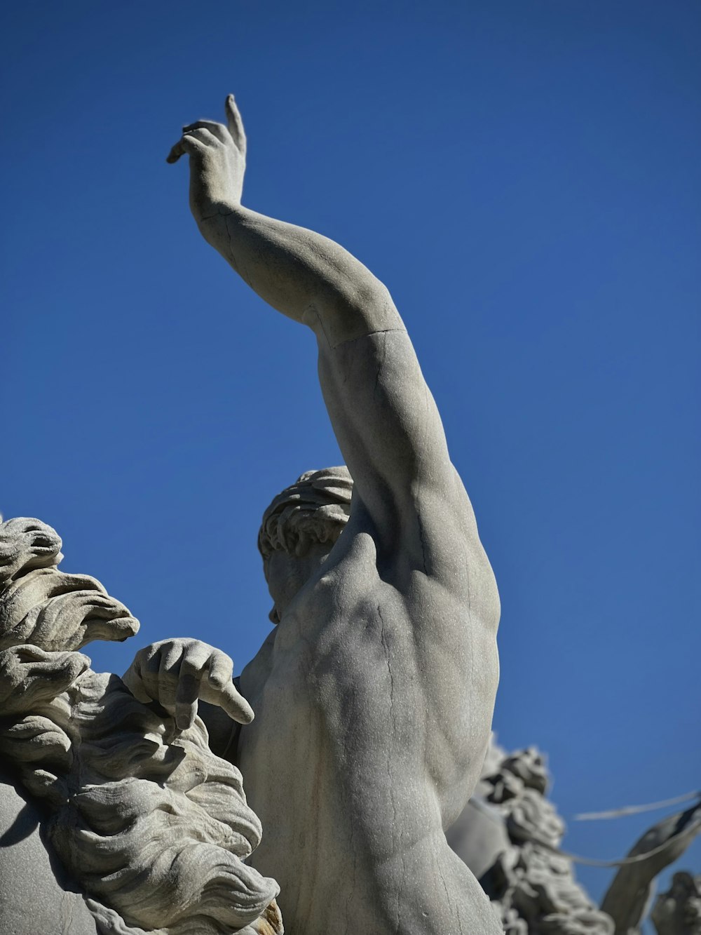 a statue of a man reaching up to the sky