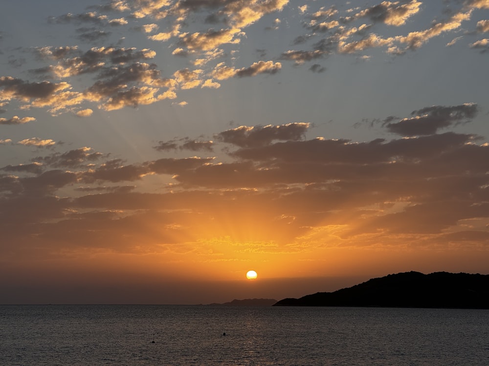 the sun is setting over a small island in the ocean