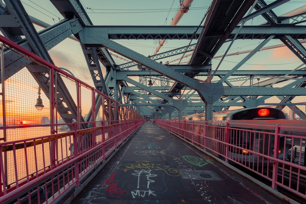 a train traveling over a bridge with graffiti on it