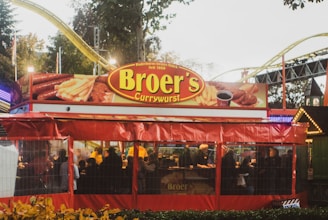 A vibrant food truck serving bratwurst at a lively outdoor event.