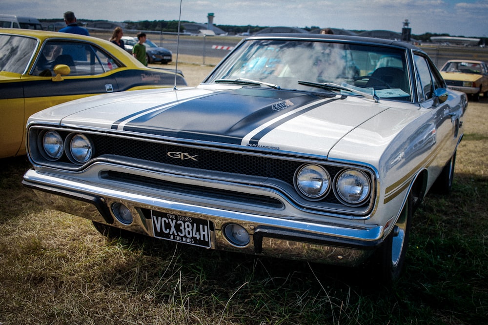 a car parked in a field next to other cars