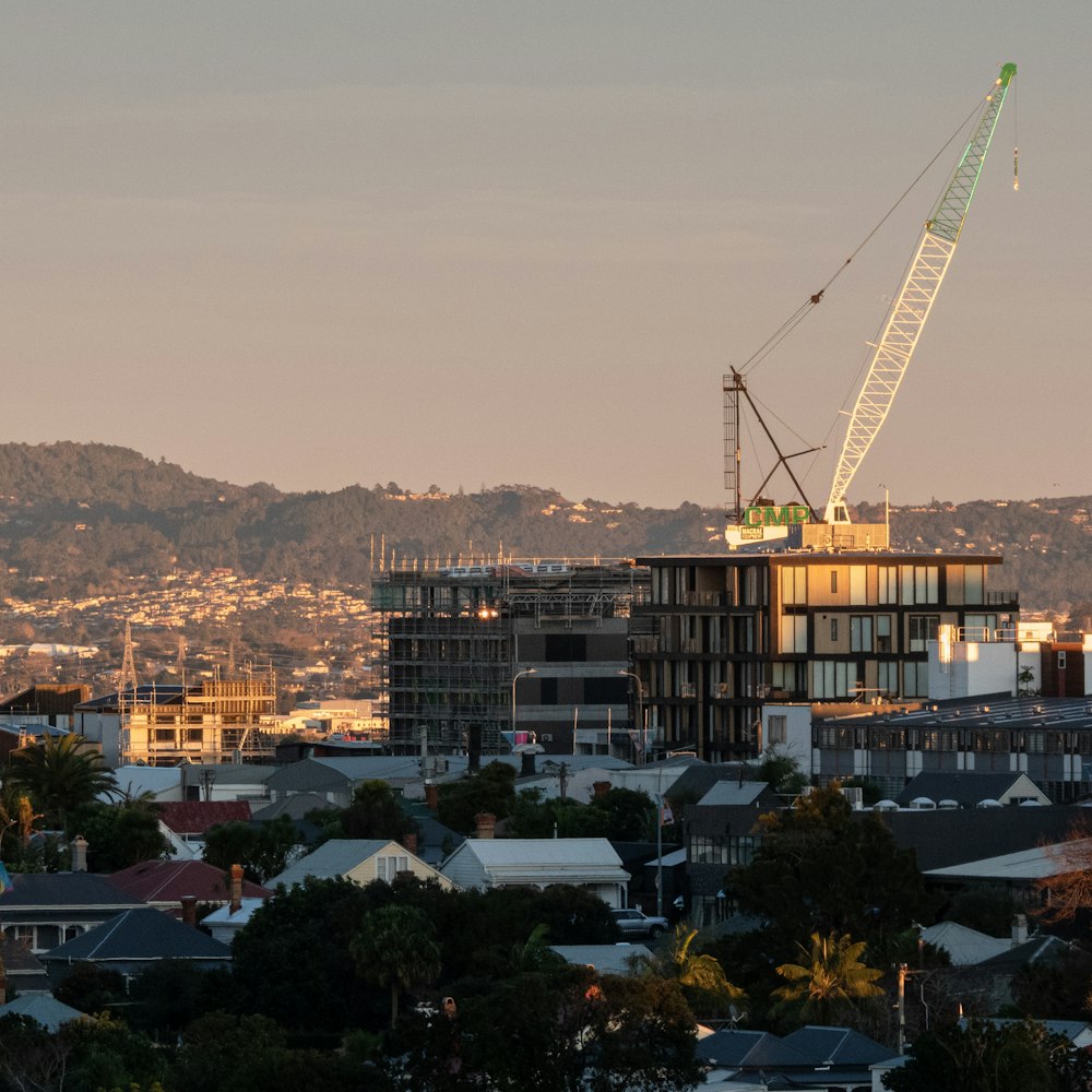 a crane on top of a building with a city in the background