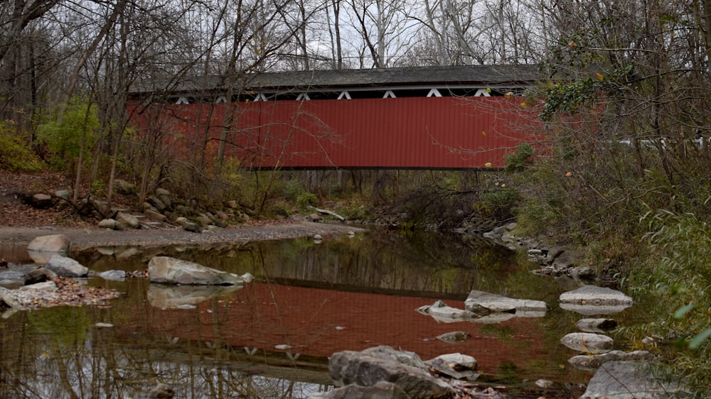 a red covered bridge over a small stream