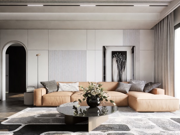 A stylish sectional sofa in a bright, sunlit room with colorful accent pillows and a wooden coffee table.