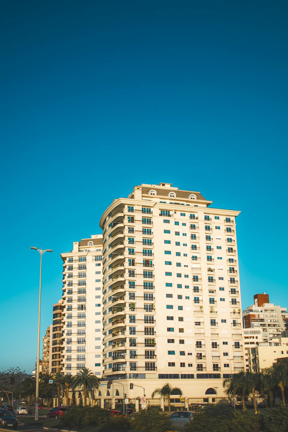 ein hohes weißes Gebäude, das neben einer Straße steht