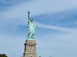 Elegant statue of the goddess of justice holding scales, set against a neutral background.