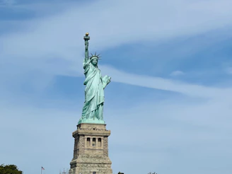 Statue of the blindfolded goddess of justice standing tall with the Andes mountains in the background under a clear sky.