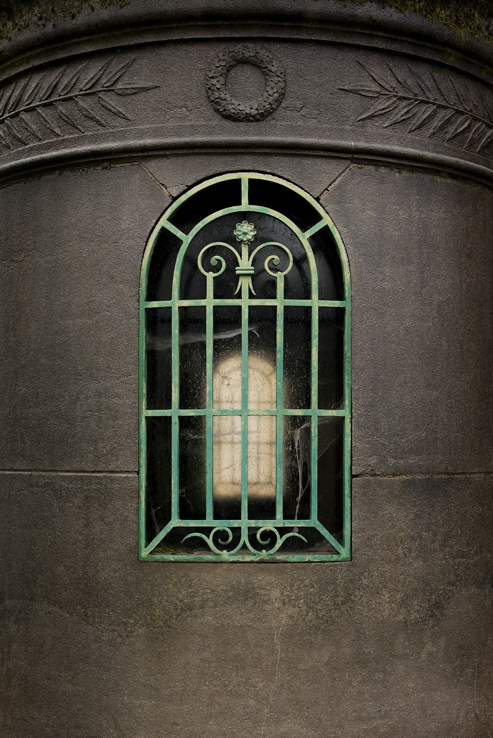 a window with a green frame on the side of a building