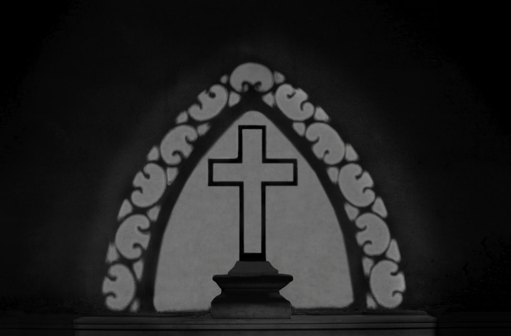 a black and white photo of a cross in a church