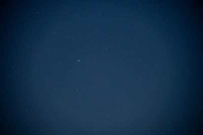 Close-up of a detailed natal chart against a deep navy, starlit background.