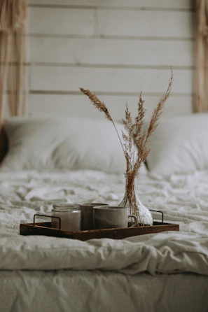 An inviting bedroom scene with a simple, elegant hand-stitched quilt and natural decor accents.
