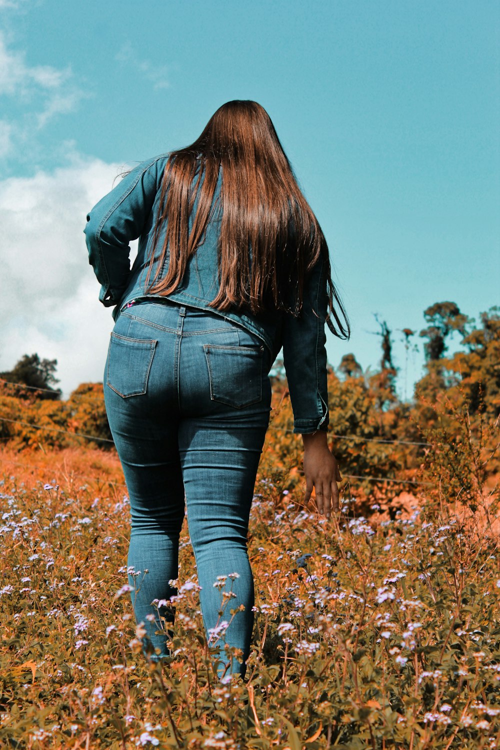 una mujer caminando por un campo de flores