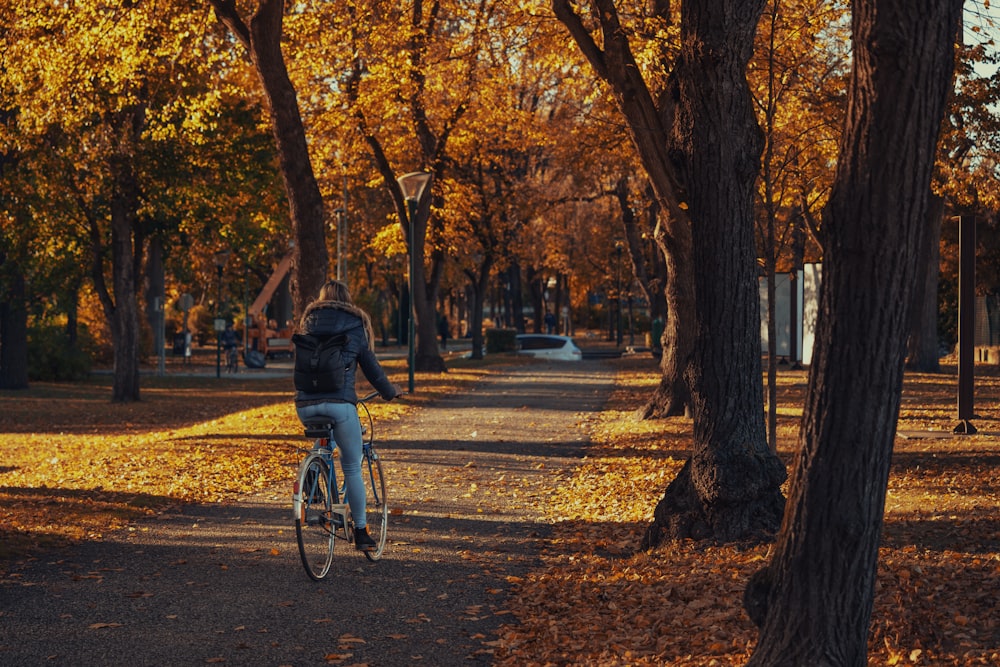 a person riding a bike through a park