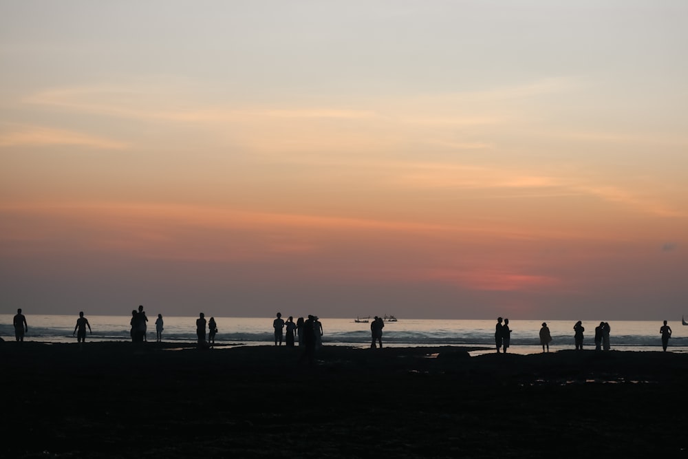 a group of people standing on top of a beach