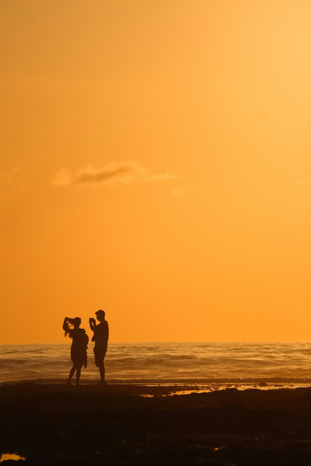 a group of people standing on top of a sandy beach