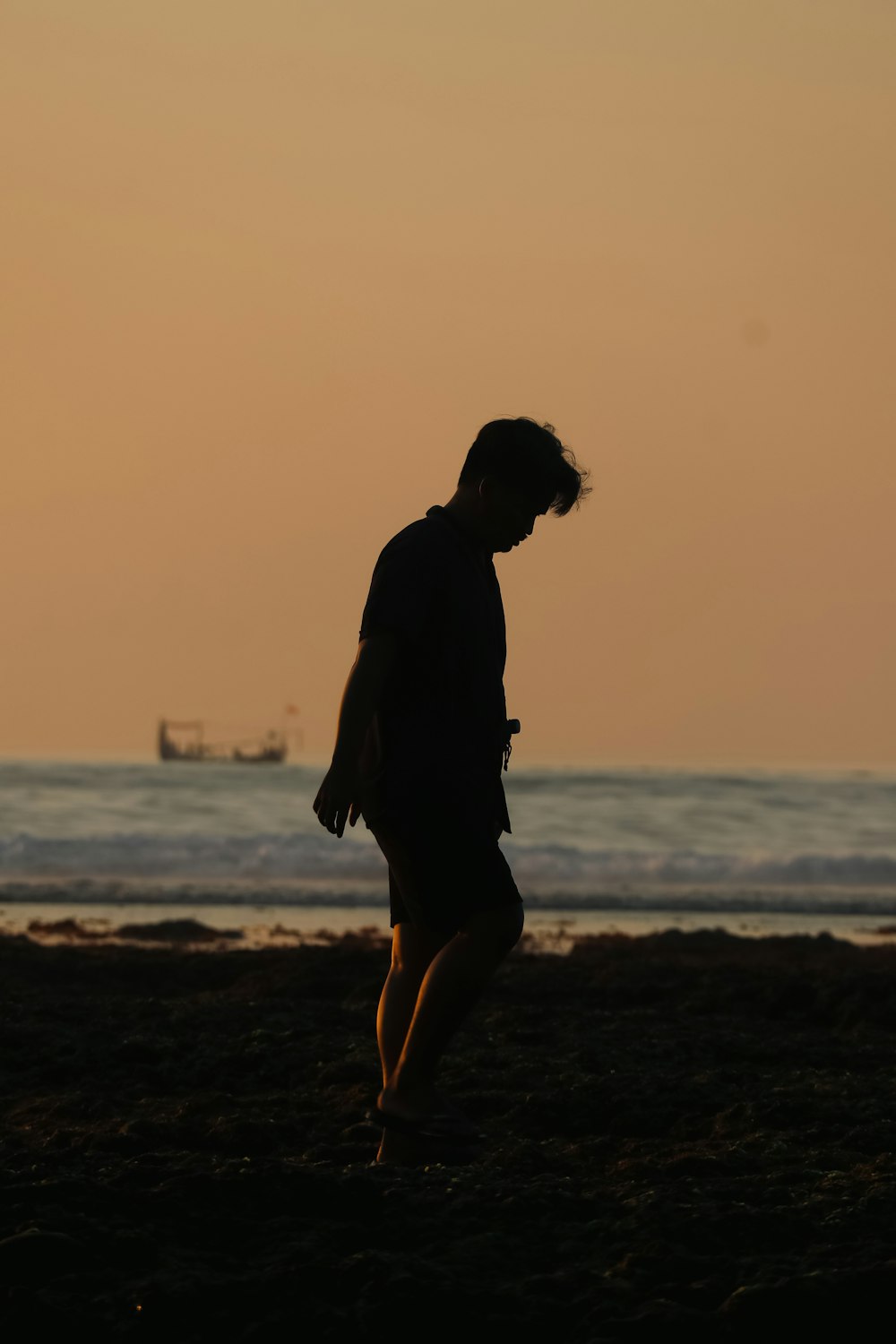 a man standing on top of a beach next to the ocean