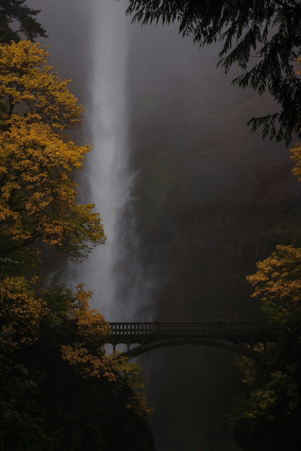 Un puente sobre un río con una cascada al fondo