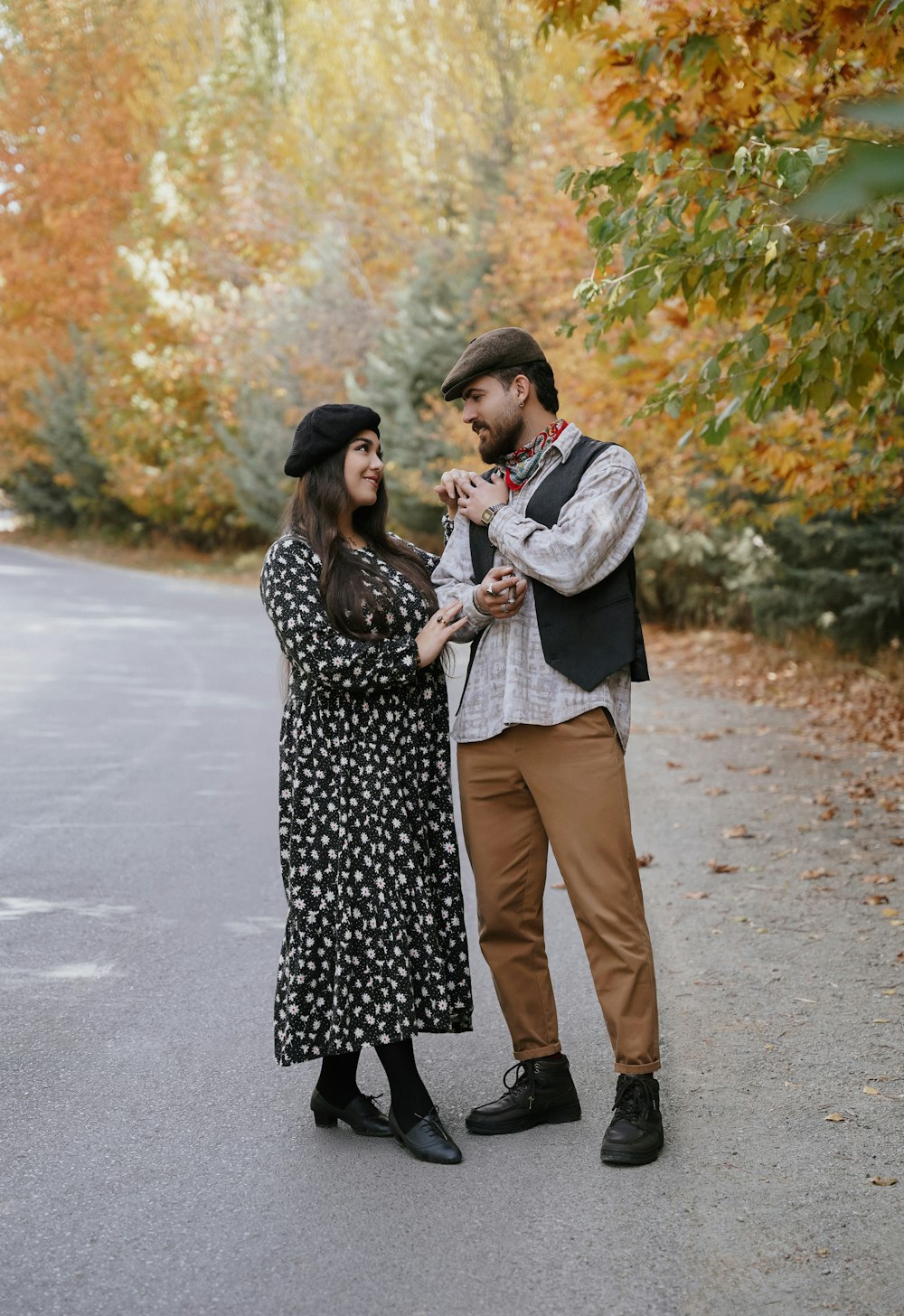 a man and woman standing next to each other on a road