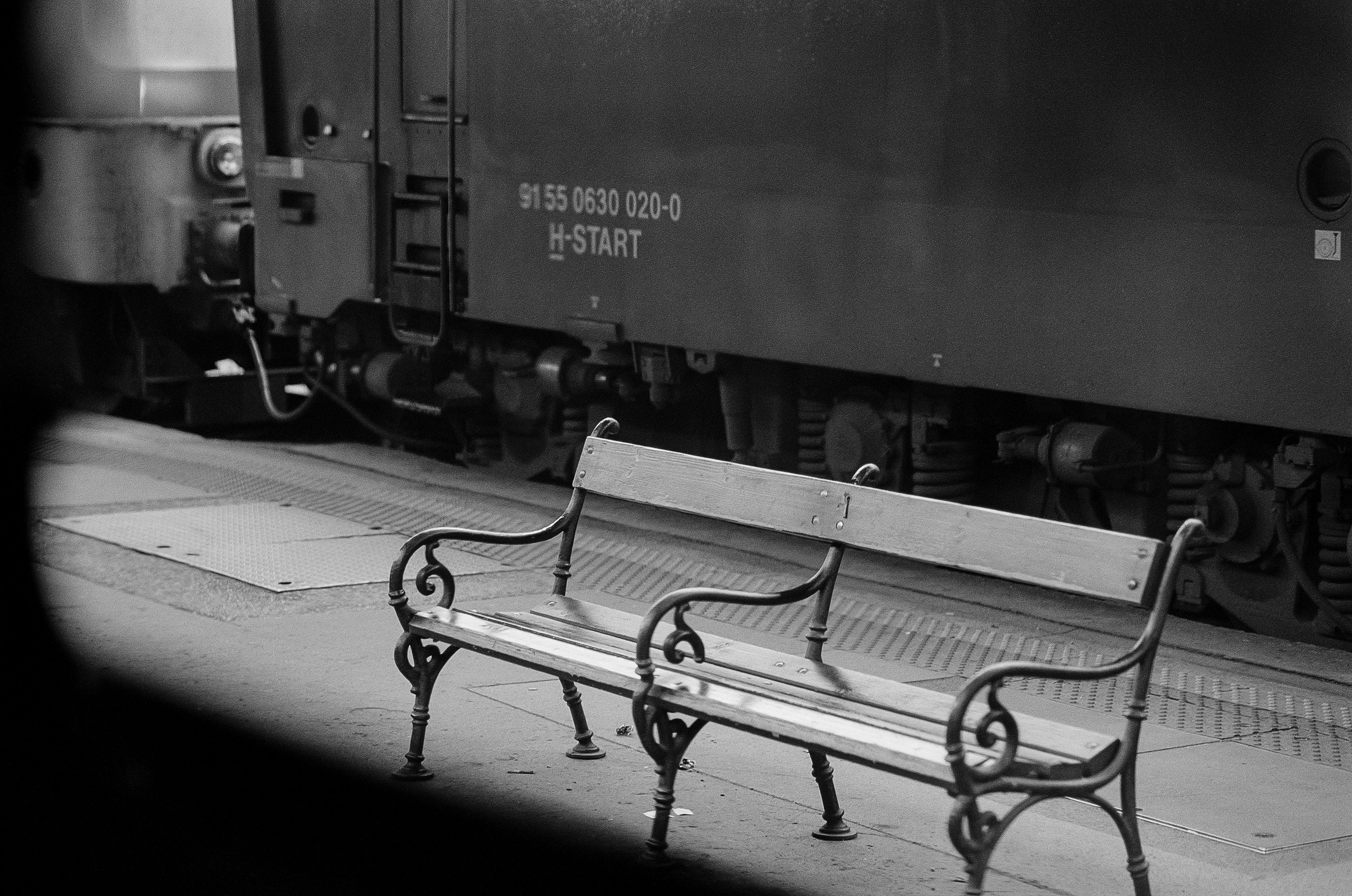 A bench sitting on the side of a train track photo – Free Grey Image on ...