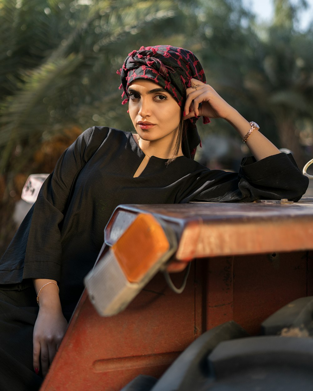 a woman with a bandana sitting on a bench