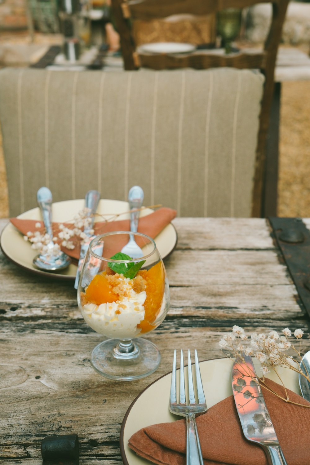 a wooden table topped with plates and silverware