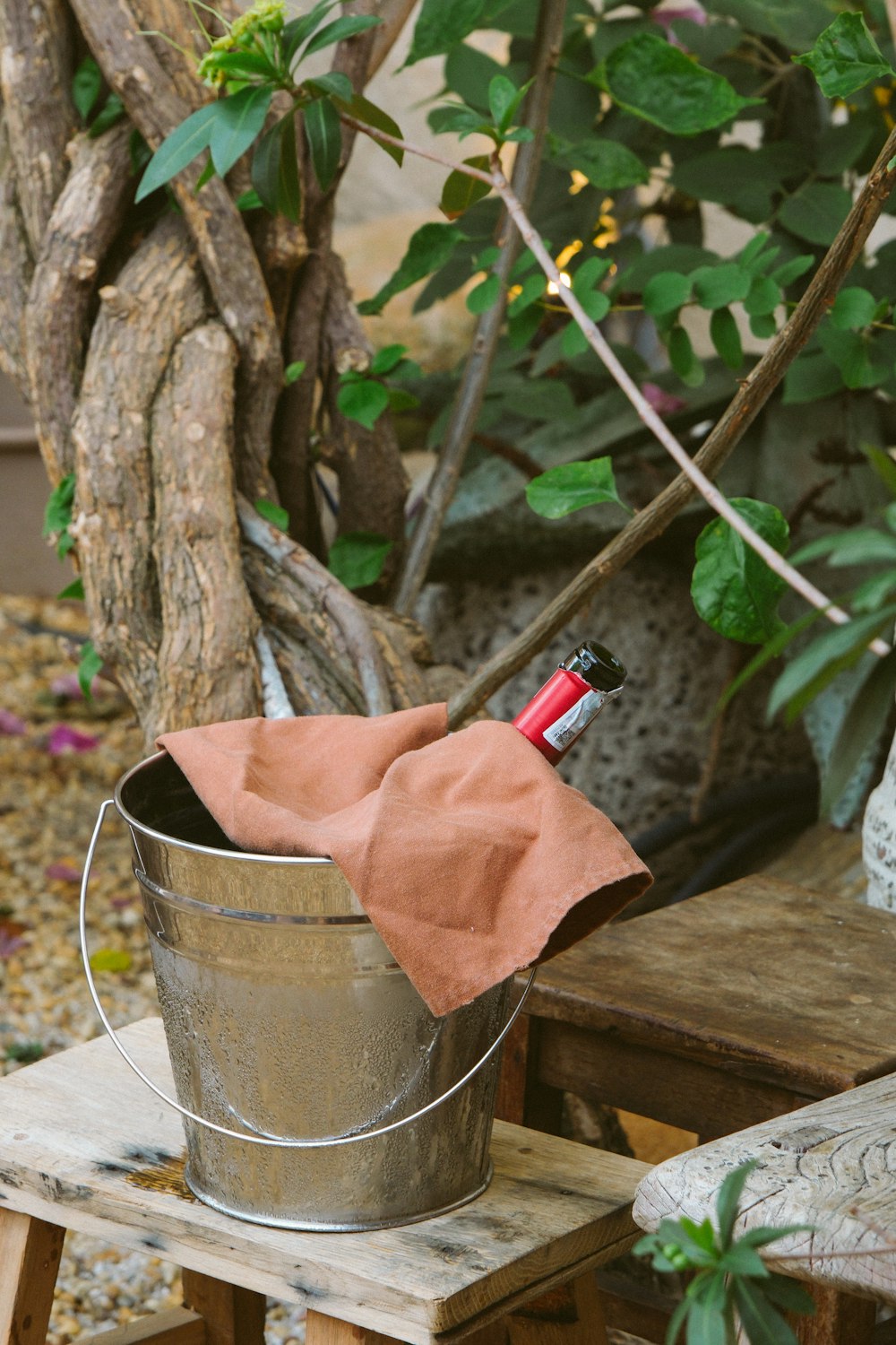 a metal bucket with a red handle on a wooden table