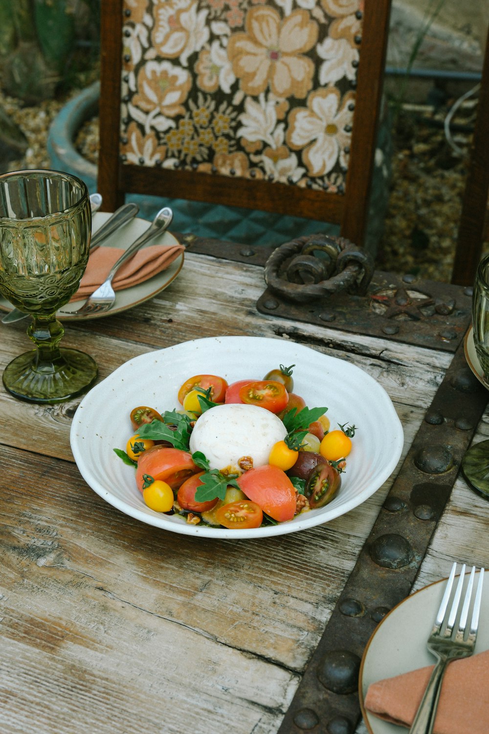 a white plate topped with a salad on top of a wooden table