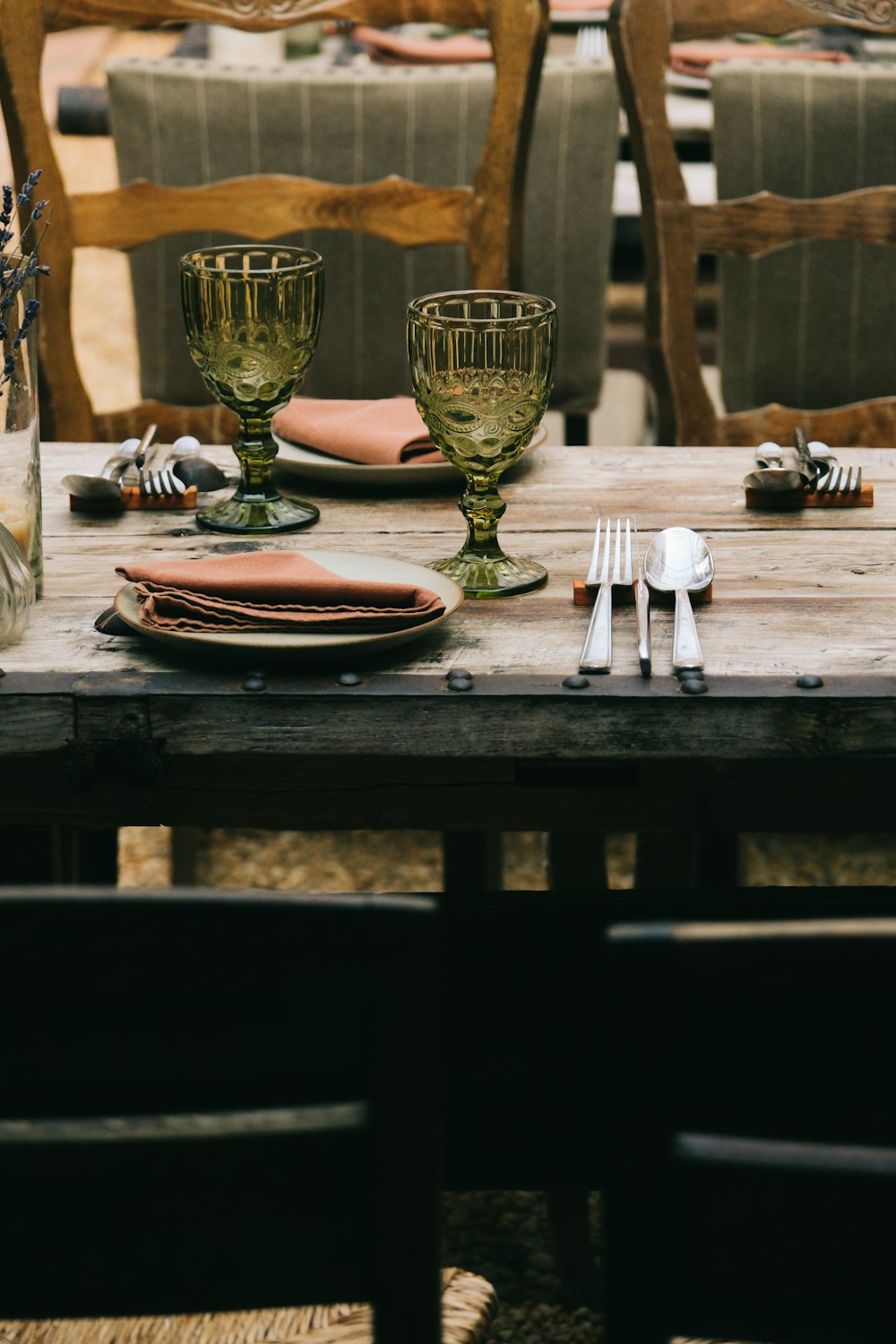 a wooden table topped with plates and glasses