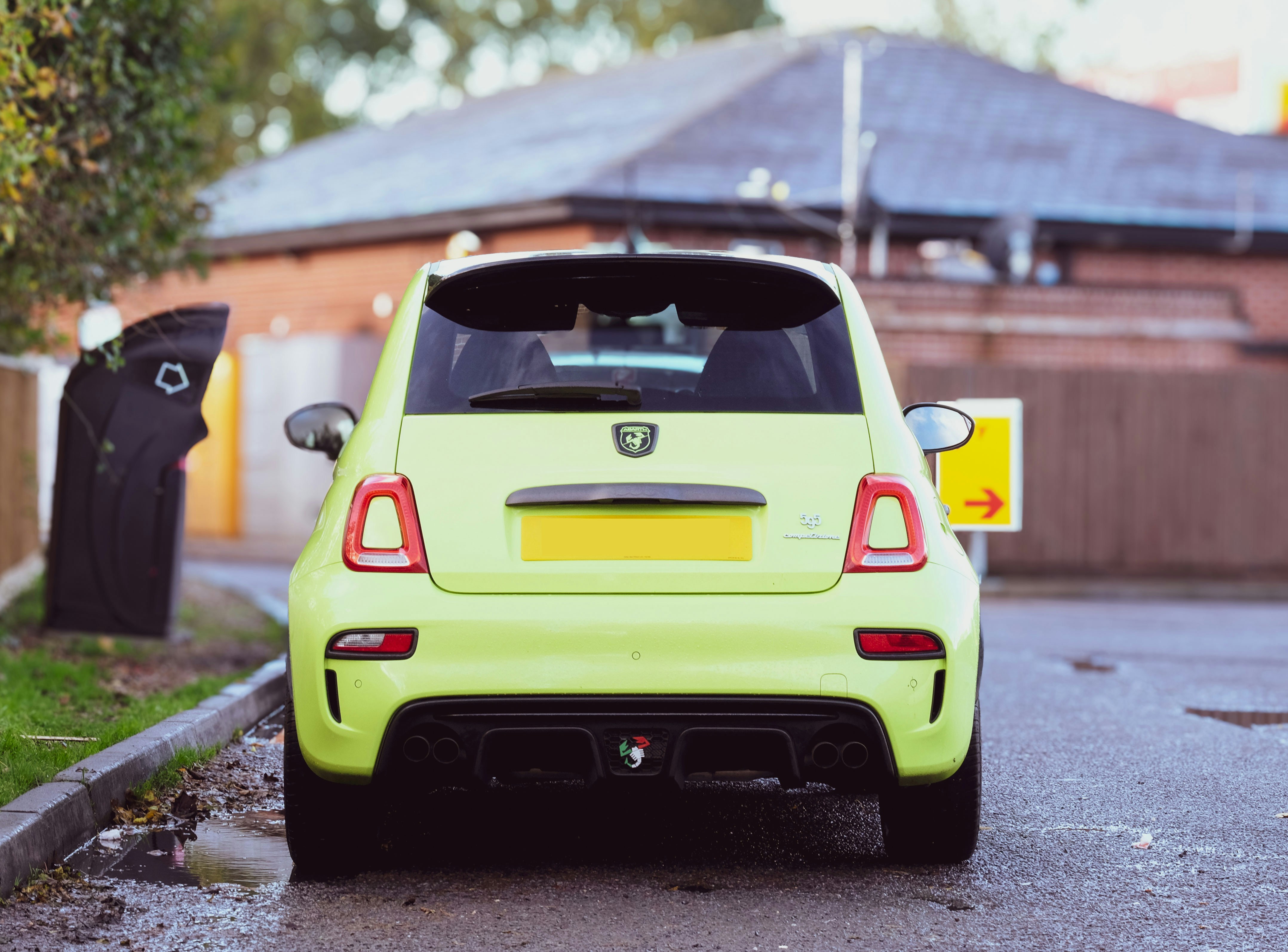 a small green car parked on the side of the road