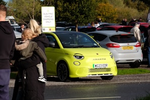 A family happily standing next to their new byd car in an urban Jakarta neighborhood.