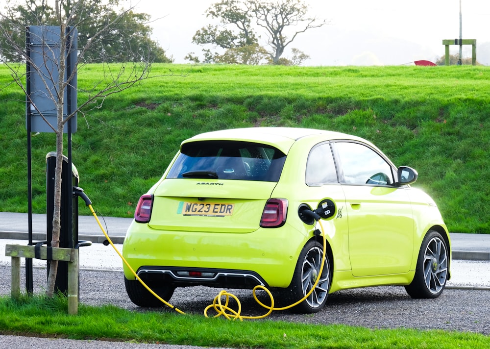 a yellow car is plugged into a charging station