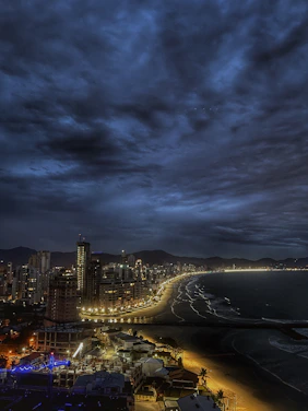 A moody nighttime shot of Atlantic City's iconic boardwalk with neon lights reflecting on wet pavement.