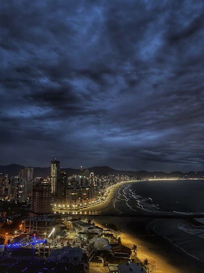 A moody nighttime shot of Atlantic City's iconic boardwalk with neon lights reflecting on wet pavement.